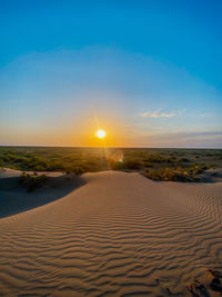 Scenic view of beach against sky during sunset