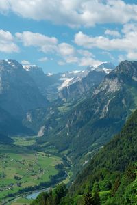 Scenic view of valley and mountains against sky