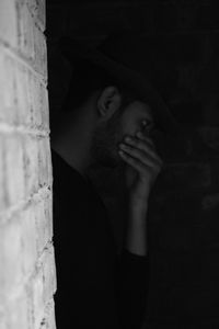 Portrait of young man smoking by window