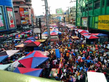 Crowd on street in city against sky