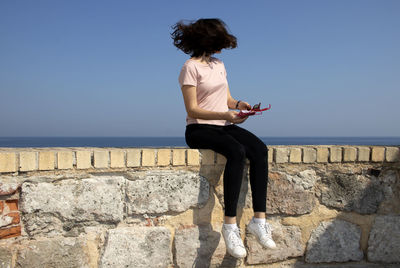 Full length of man looking at sea against sky