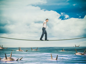 Man standing in sea against sky