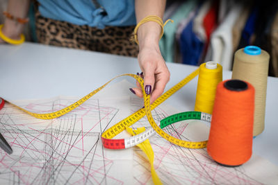 Midsection of woman holding tape measure