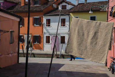 Clothes drying on alley amidst buildings in city