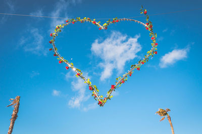 Low angle view of heart shape against blue sky
