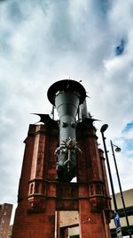 Low angle view of building against cloudy sky