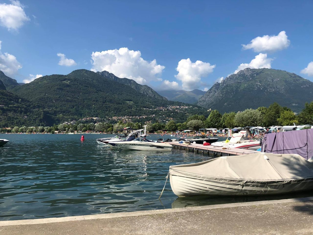 SAILBOATS MOORED ON SEA AGAINST MOUNTAINS