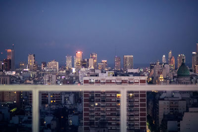 Illuminated buildings in city against sky at night