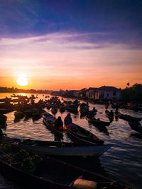 People in city against sky during sunset