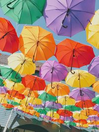 Low angle view of multi colored umbrellas hanging outdoors
