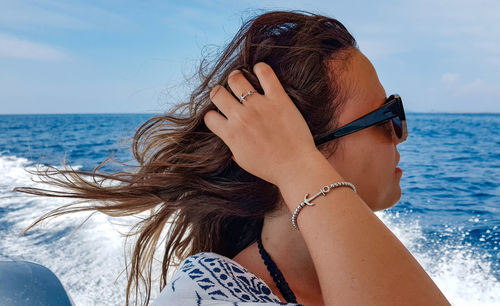 Young woman on boat at sea. wind in hair, lifestyle, summer vacation.