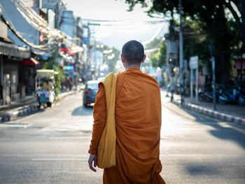 Rear view of monk standing on street