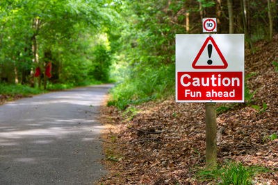 Road sign by trees in city