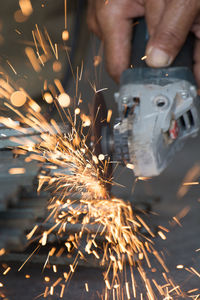 Cropped hands of man welding metal