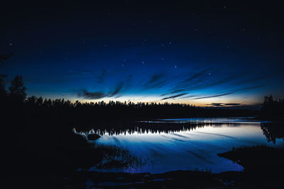 Scenic view of lake against sky at night