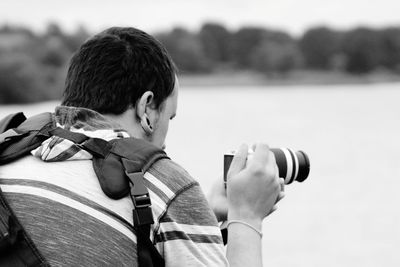 Rear view of boy photographing