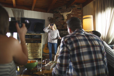 Friends playing heads up game during social gathering at home