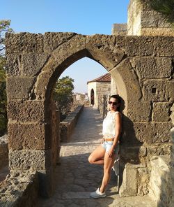 Portrait of young woman against historic building