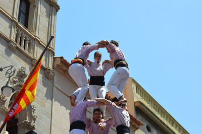 Low angle view of people against clear sky