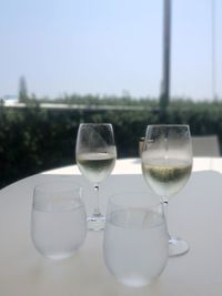 Close-up of wine glasses on table against sky