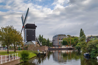 Buildings by lake against sky in city