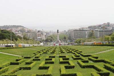 Panoramic view of garden by buildings against clear sky