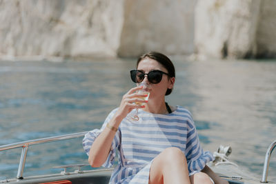 Portrait of a young girl drinking champagne in a boat.