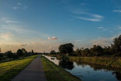 Scenic view of canal against sky during sunset