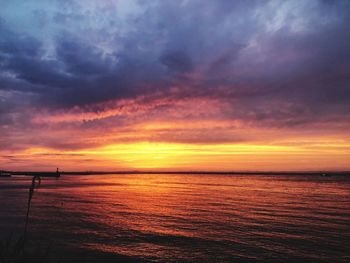 Scenic view of sea against dramatic sky during sunset