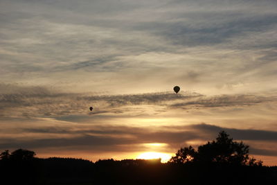 Silhouette hot air balloon against sky during sunset