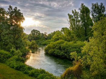 Scenic view of river against cloudy sky
