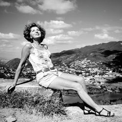 Rear view of woman standing on mountain against sky