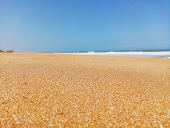 Surface level of beach against clear sky