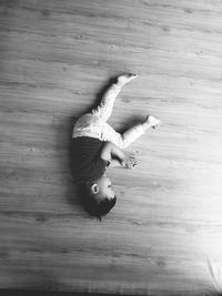 High angle view of boy sleeping on hardwood floor at home