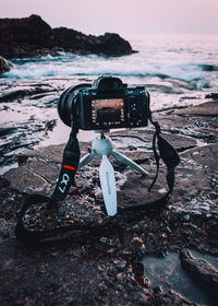 Vintage camera on beach against sky