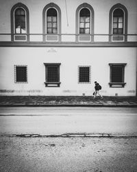 Man walking on road against building