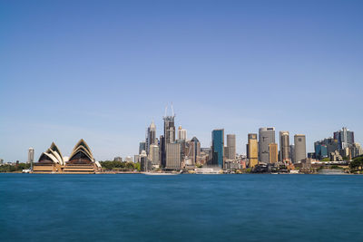 Buildings in city against clear blue sky