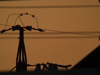 Low angle view of silhouette chain against sky during sunset