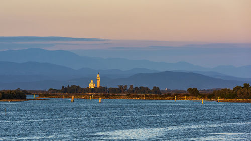 Sunset on the grado marano lagoon and a glimpse of the island of barbana.