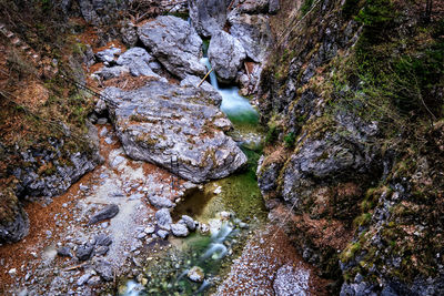 High angle view of stream amidst rocks in forest