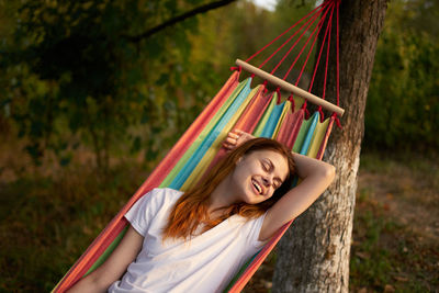 Mid section of man in hammock against trees