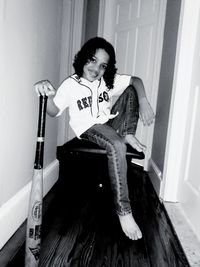 Portrait of young woman sitting on chair at home