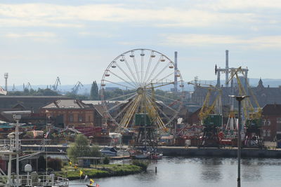 Ferris wheel at harbor against sky