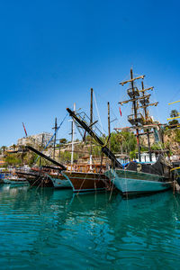 Boats in sea against clear blue sky