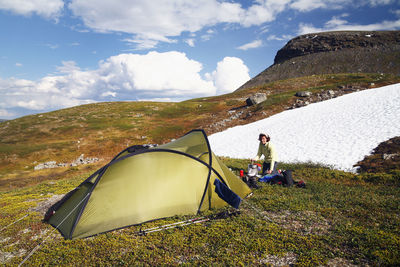 Woman near tent in mountains