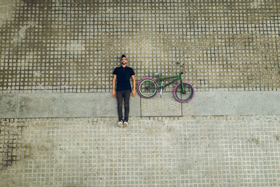 Full length of man riding bicycle on footpath