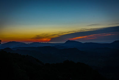 Scenic view of silhouette mountains against sky during sunset