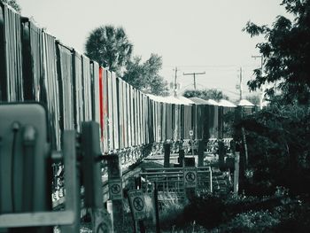 Train by factory against sky