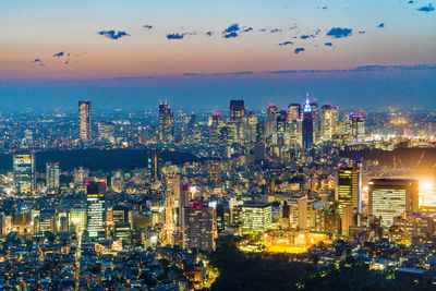 High angle view of illuminated city buildings against sky