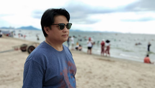 Man wearing sunglasses standing on beach